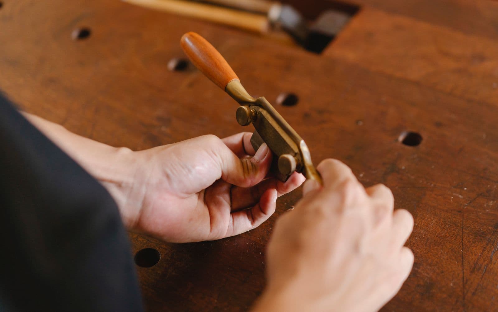Les mains d'un artisan au rabot.