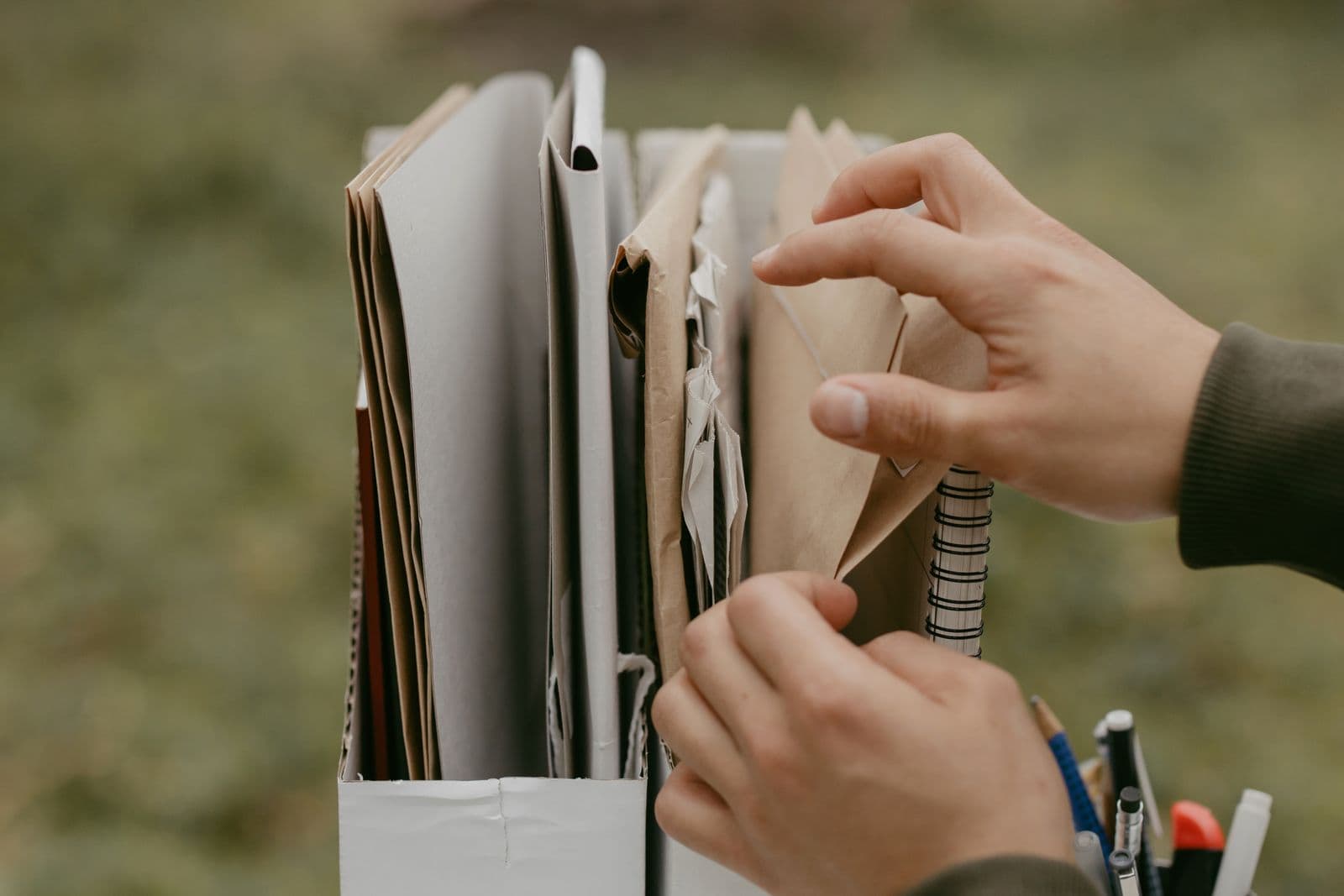 Des mains classent des documents et des enveloppes.